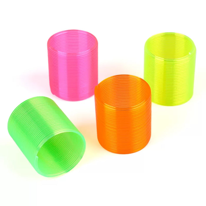 Four neon rainbow spring toys in pink, green, orange and yellow on white background