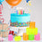 Neon rainbow spring toys displayed at birthday party with cake and balloons