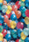 Folded gift wrap with colourful photographic balloons and scattered confetti on a dark background