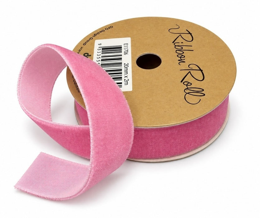 Light pink velvet ribbon on a gold-coloured spool with a loose length showing its textured surface and smooth reverse