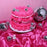 Hot pink cake with piped ruffles and silver disco balls beside a Colour Mill Hot Pink bottle