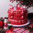 Red and pink piped Christmas cake with Santa decorations beside Colour Mill Red food colour