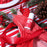 Colour Mill Red bottle on red icing piping bags with festive ribbon and pinecones