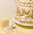 Colour Mill Sand bottle beside beige cake piping and shell decorations