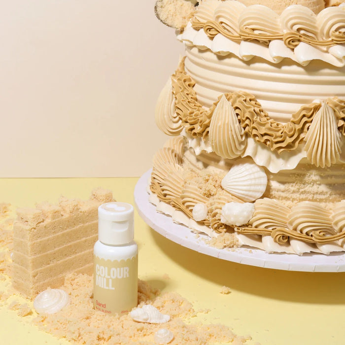 Colour Mill Sand bottle beside beige cake piping and shell decorations