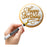 Gold edible metallic pen writing Happy Birthday in script on a white iced cookie