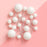 Assorted white ball cake toppers on slender picks against a pink background