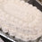 White cake with intricate piped icing on a silver tray