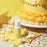 Colour Mill Yellow bottle beside yellow buttercream cake ruffles and popcorn