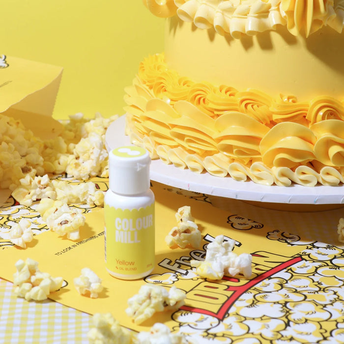 Colour Mill Yellow bottle beside yellow buttercream cake ruffles and popcorn