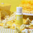 Colour Mill Yellow Oil Blend bottle surrounded by popcorn beside a yellow cake