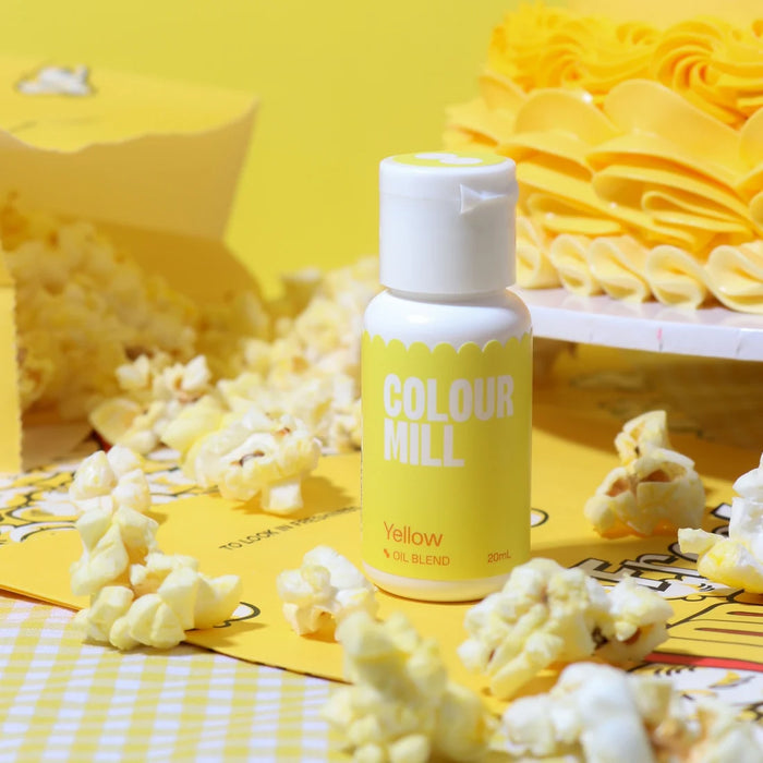 Colour Mill Yellow Oil Blend bottle surrounded by popcorn beside a yellow cake